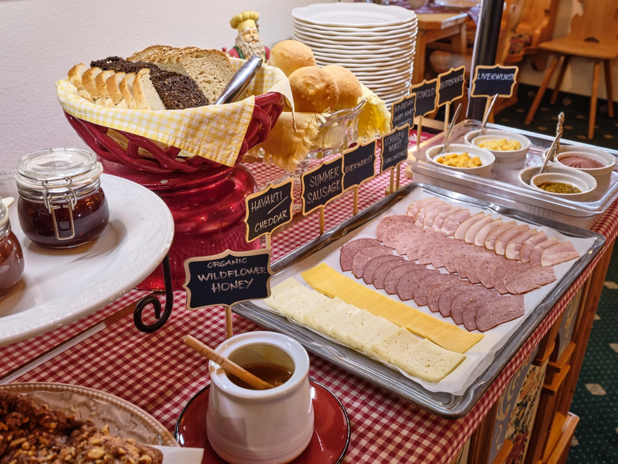 Bavarian breakfast buffet close-up — breads, meats, cheeses, honey and preserves with chalkboard labels