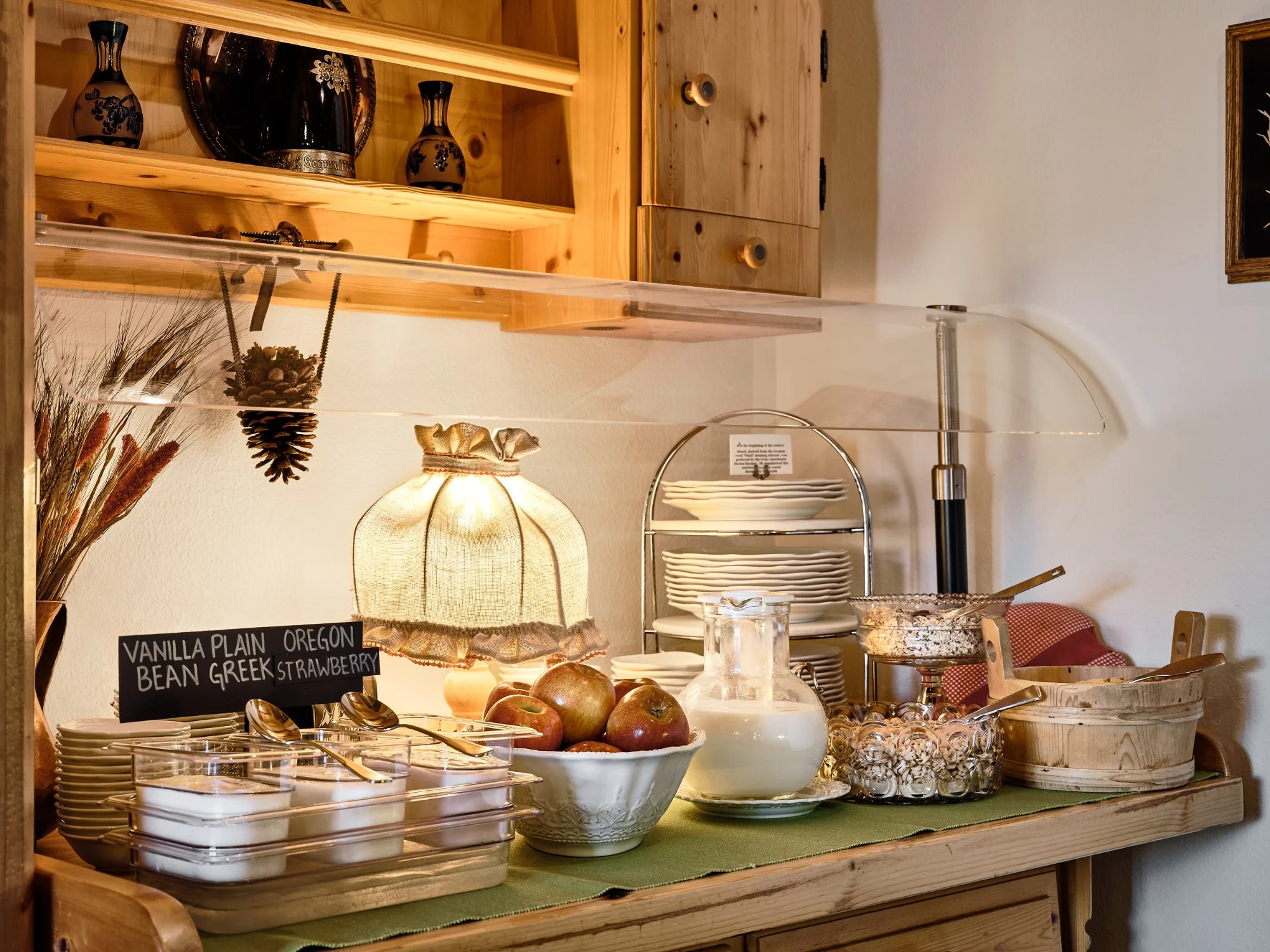 Breakfast sideboard with warm lamp, apples, milk, muesli, and yogurt selections