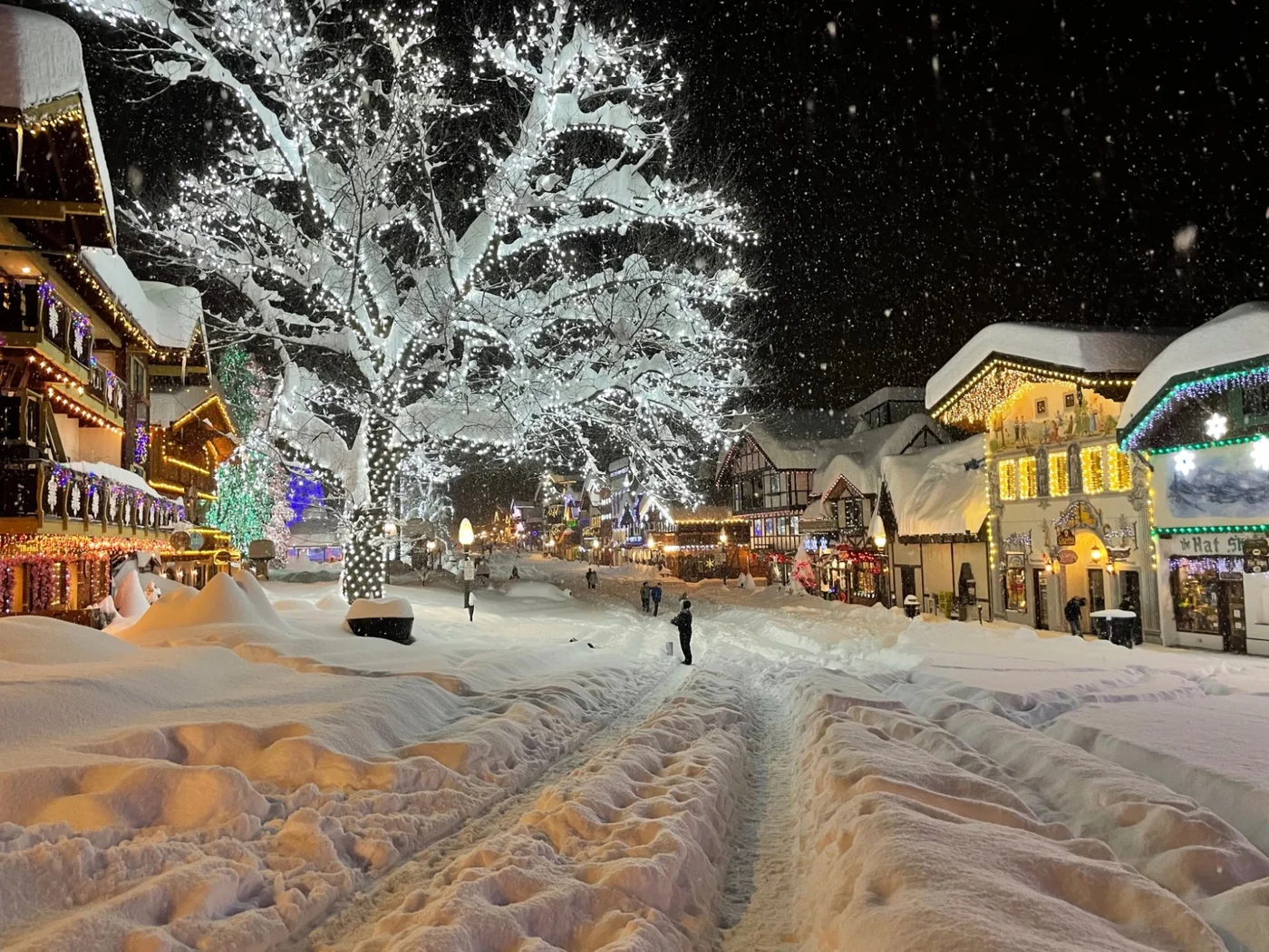 Leavenworth main street during heavy snowstorm at night with lit trees and Bavarian buildings
