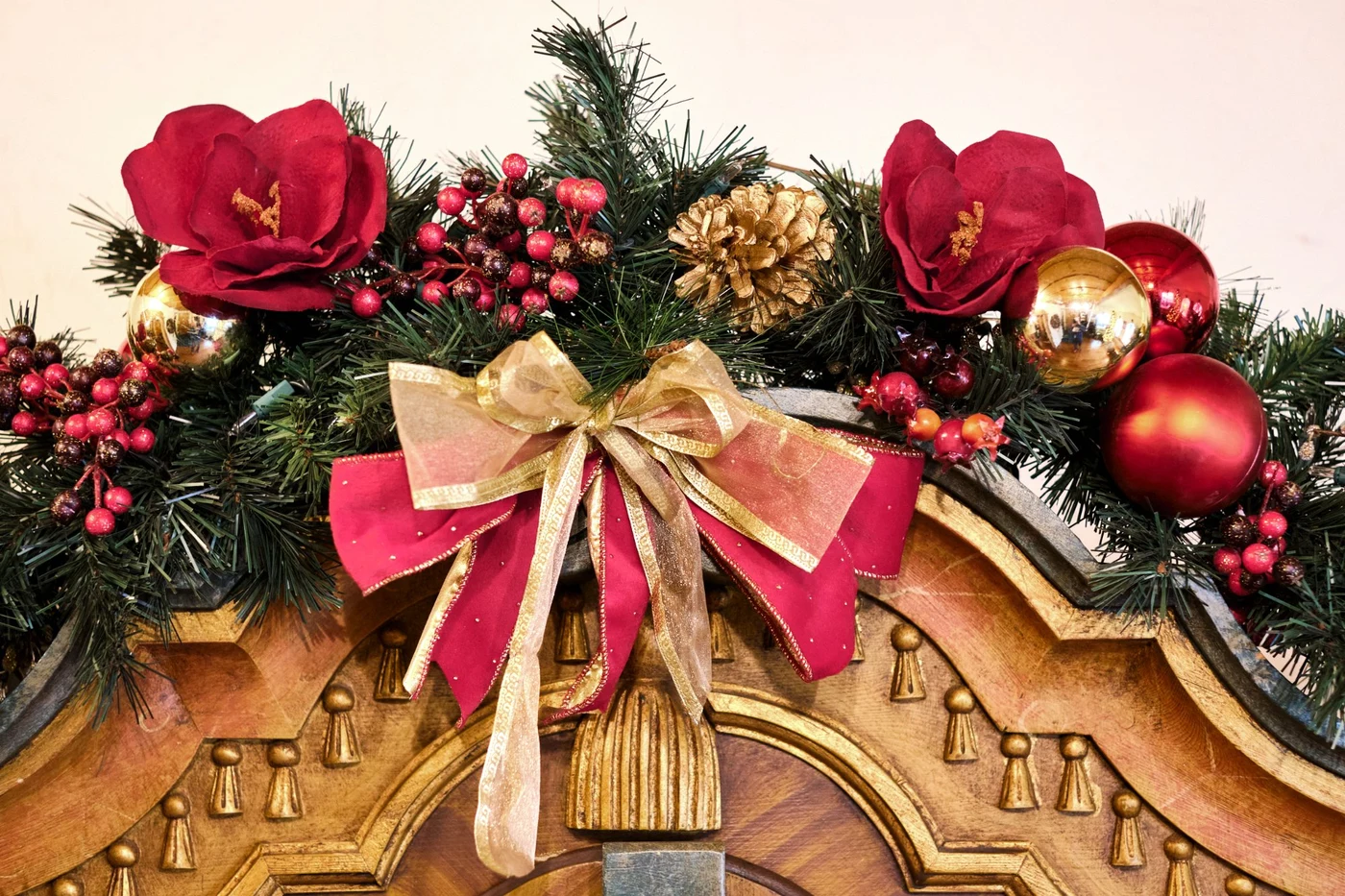 Christmas garland and bow draped over antique carved furniture at Pension Anna