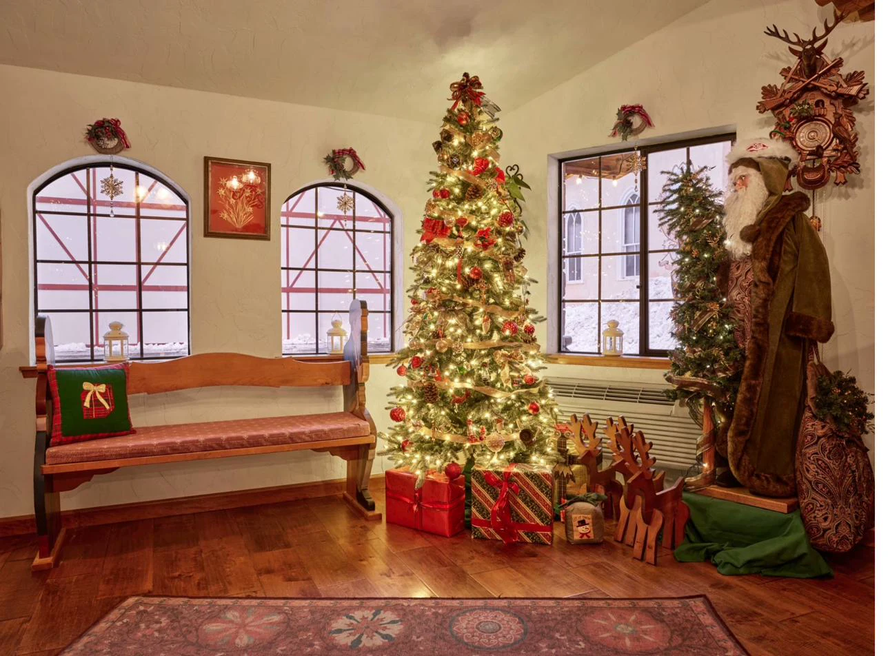 Pension Anna lobby decorated for Christmas with glowing tree, arched windows, and Santa figure