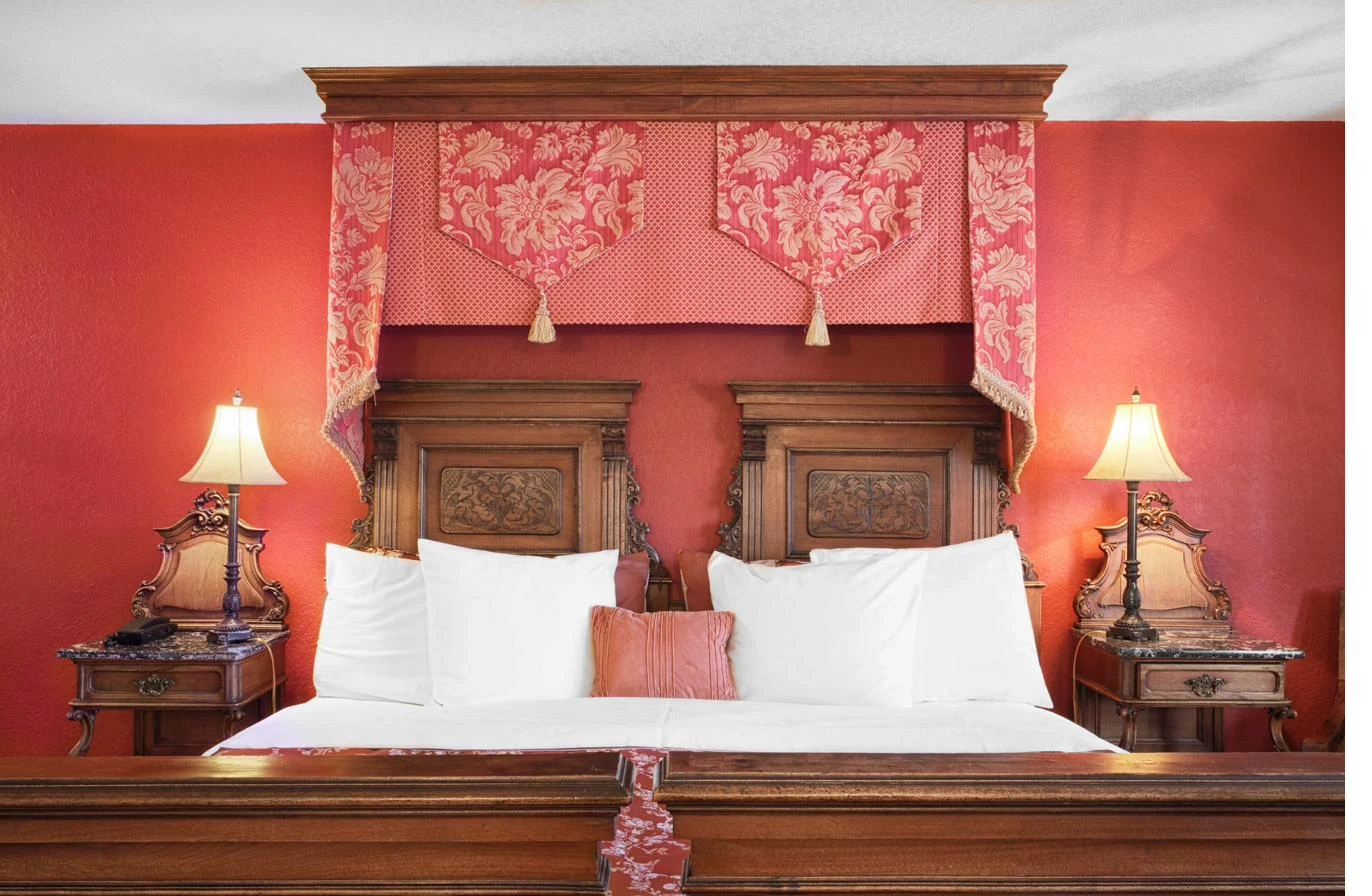 Pension Anna red suite with antique carved headboard and warm lamp light