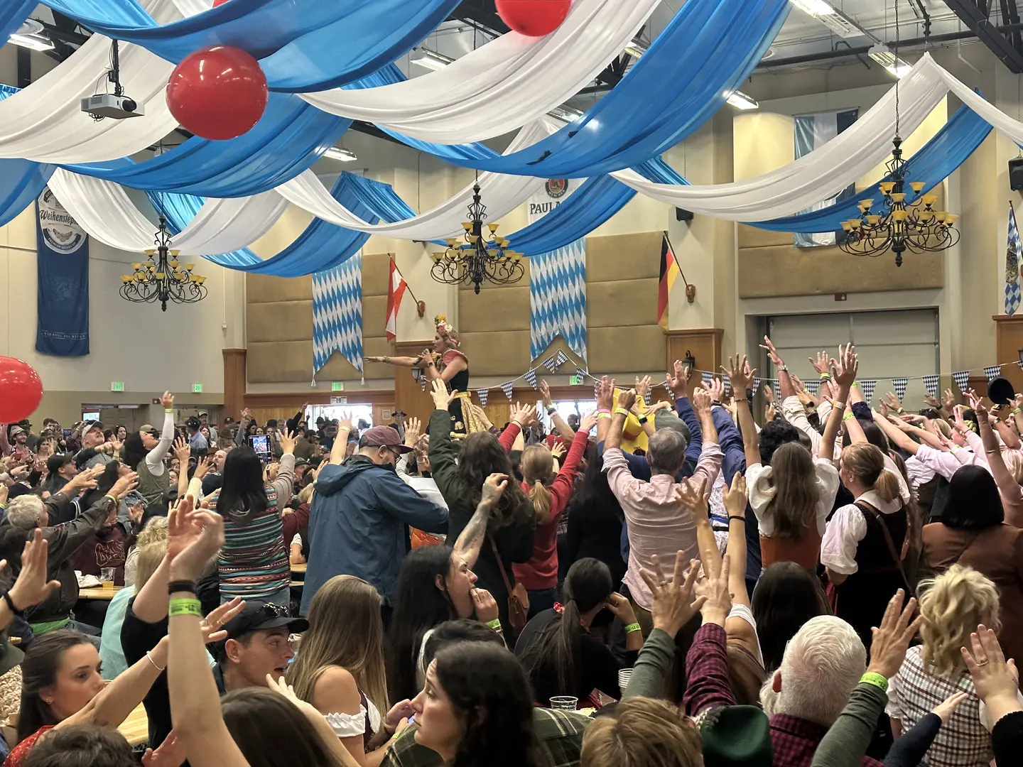 Packed crowd inside the Festhalle with hands raised at Leavenworth Oktoberfest