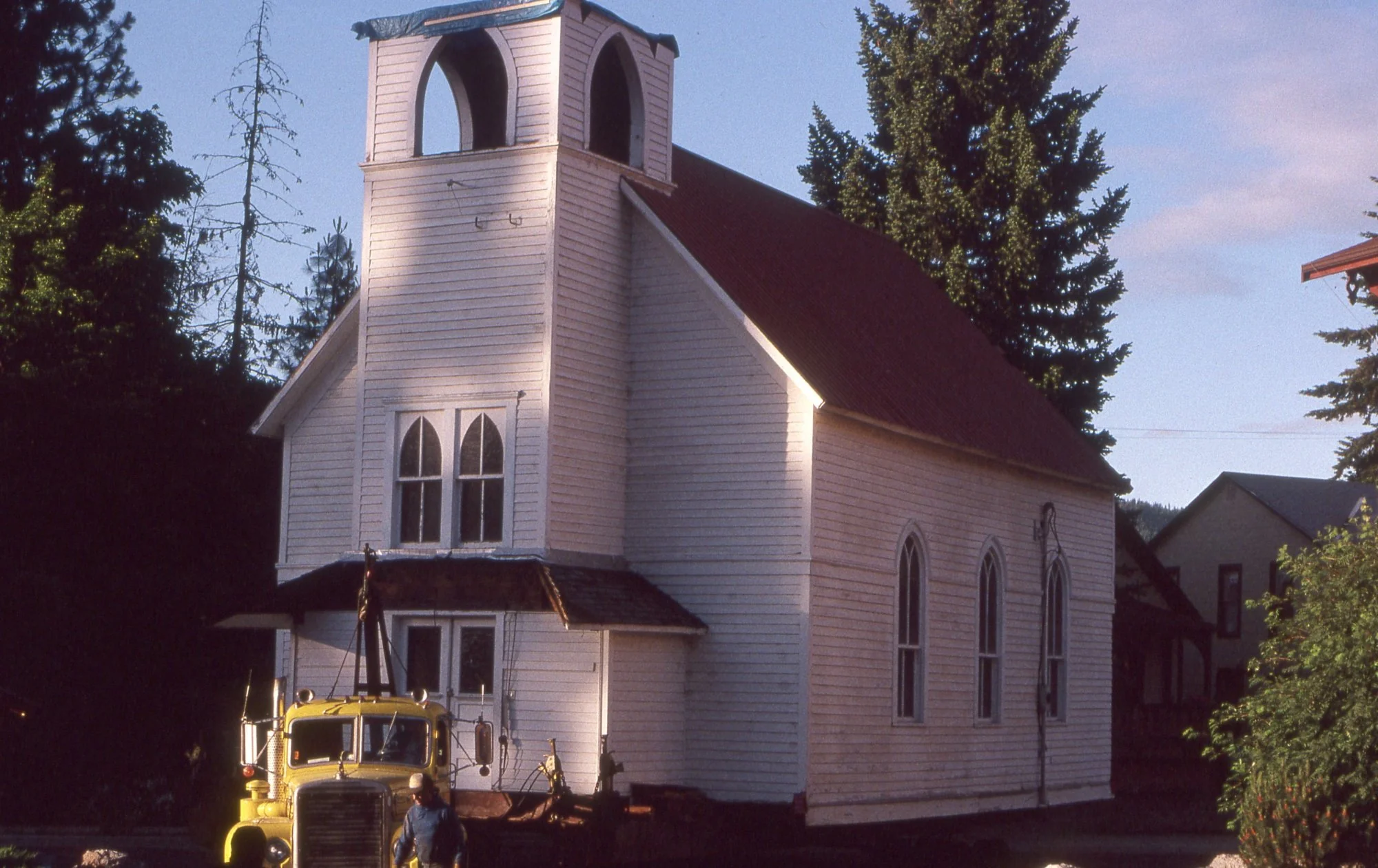 Close-up of the chapel being transported on a flatbed truck, bell tower illuminated in early morning light
