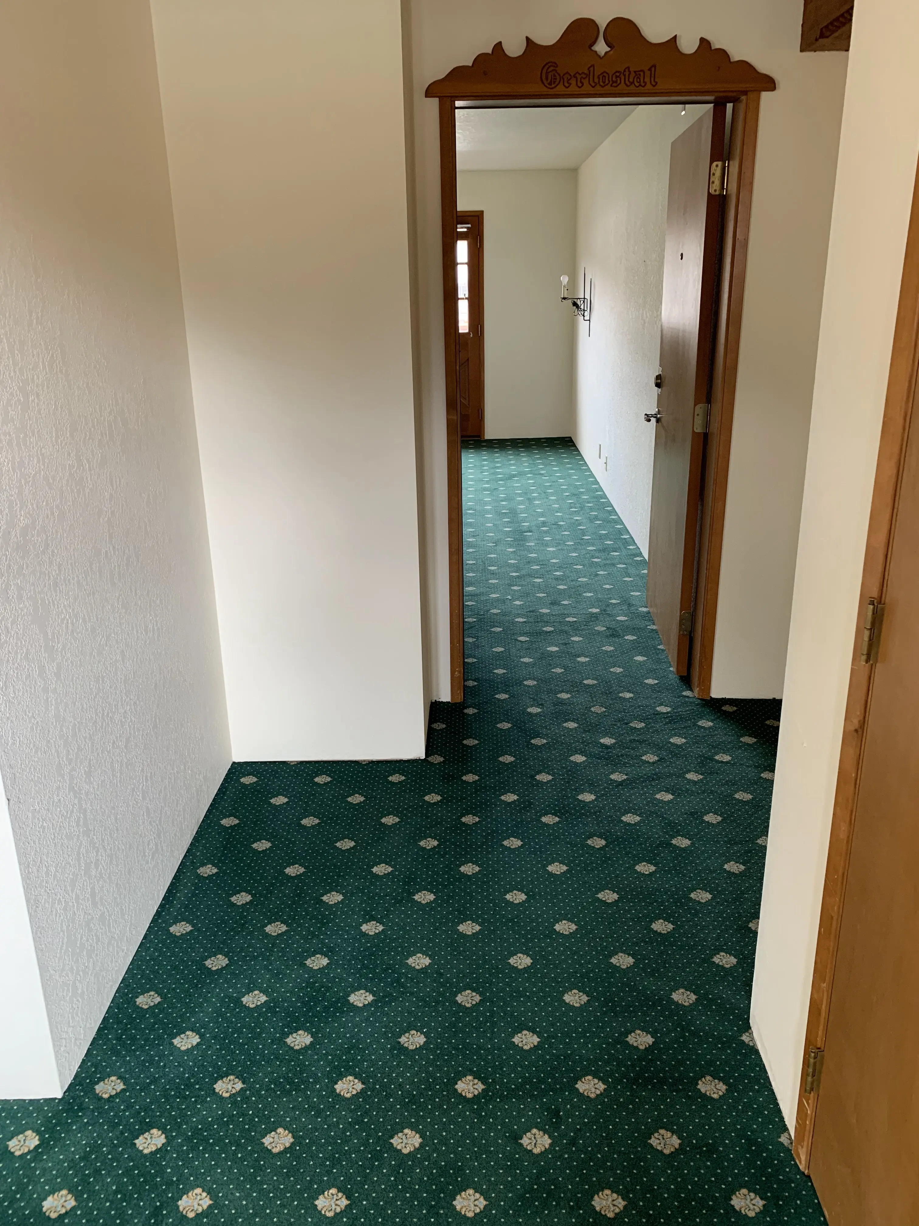 New Bavarian carpet from Germany running through the carved Gerlostal hallway doorframe at Pension Anna