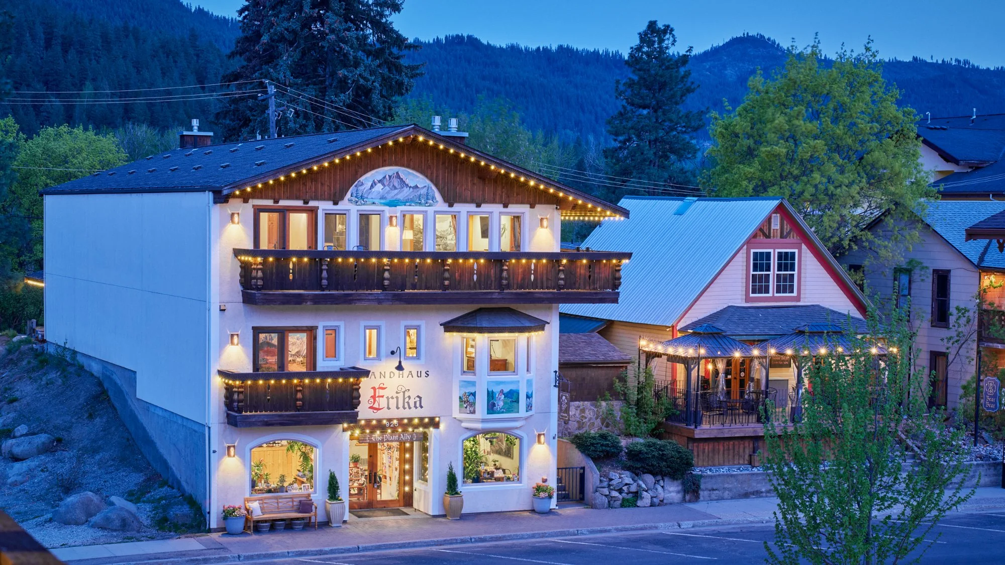 Landhaus Erika at night — Tirolean chalet with string lights, Cascade mountains behind, Leavenworth village