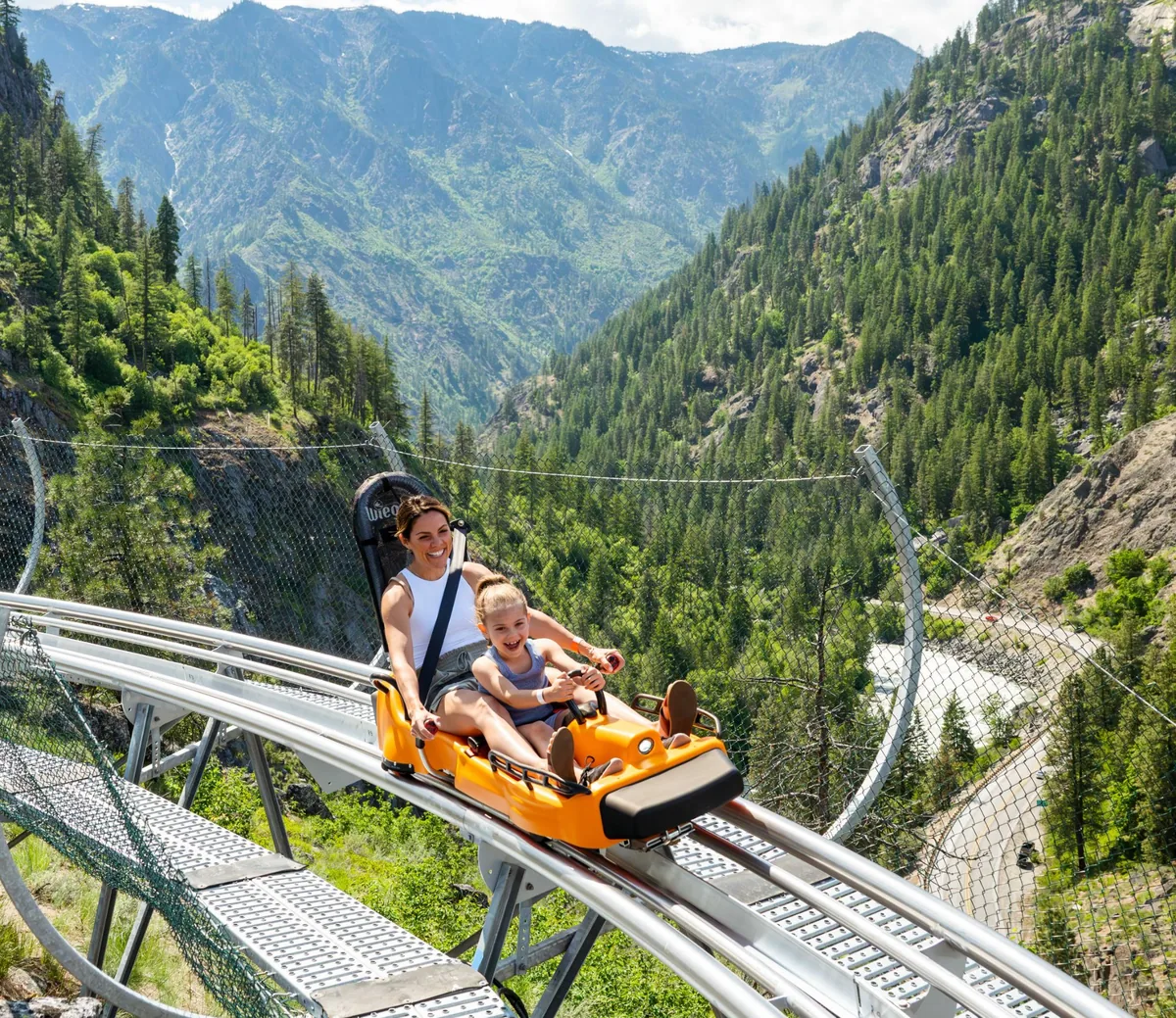 Mother and daughter riding the Tumwater Twister alpine coaster above Icicle Canyon, Leavenworth Adventure Park