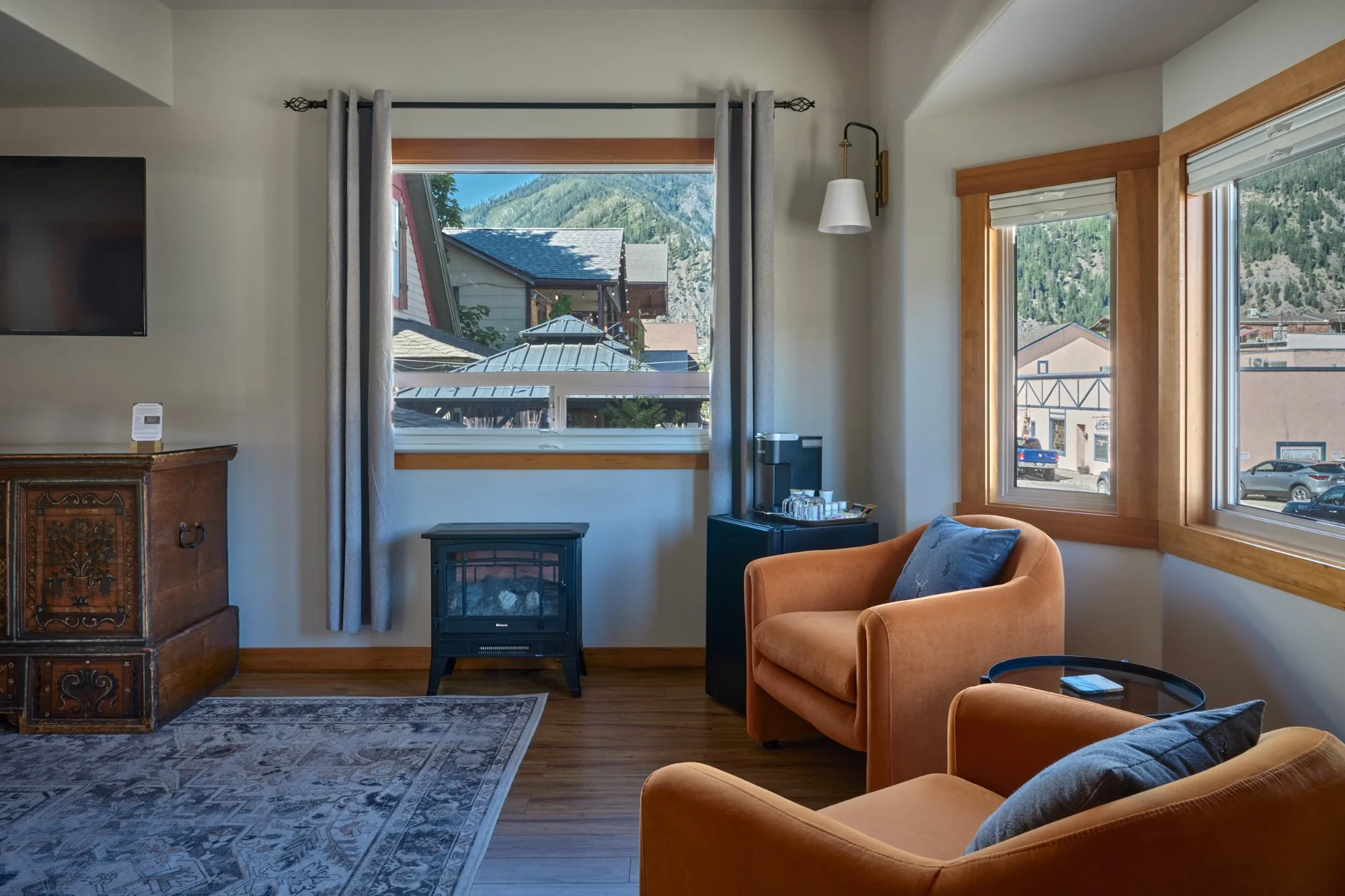 Solstice Suite living room with orange armchairs and electric fireplace