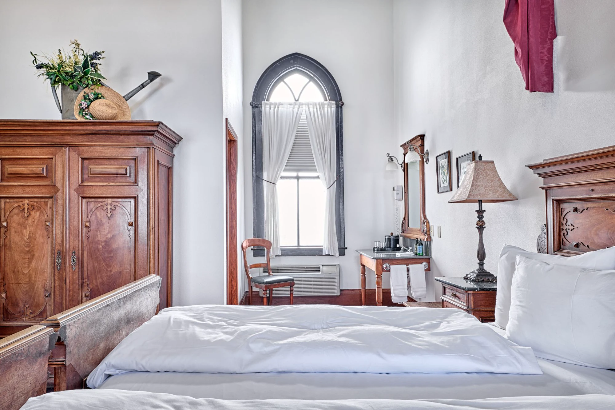 Pfaffenwinkl antique armoire, Gothic arched window, and in-room vanity