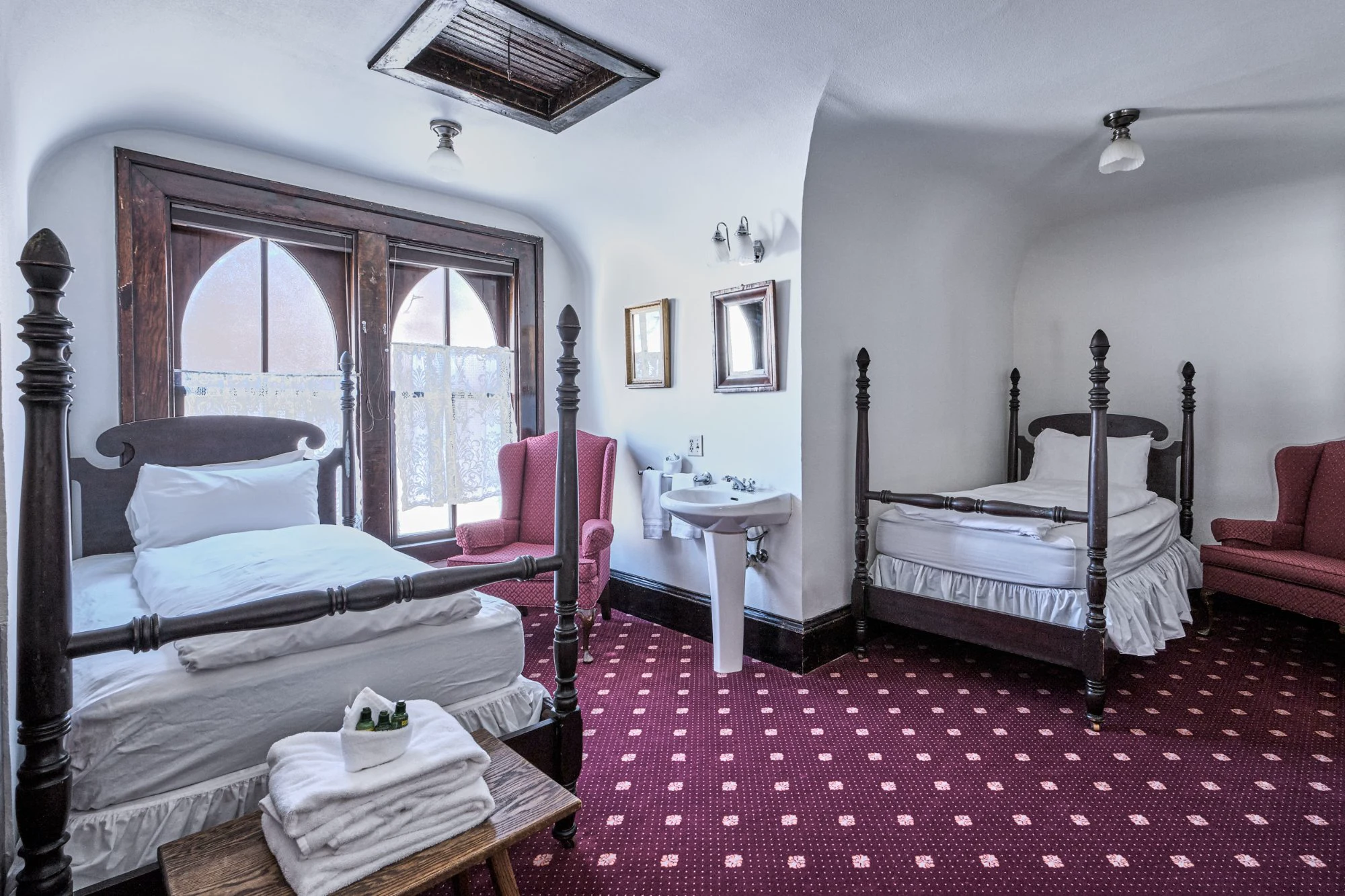 Alte Kapelle choir loft with two antique four-poster beds and Gothic arched windows