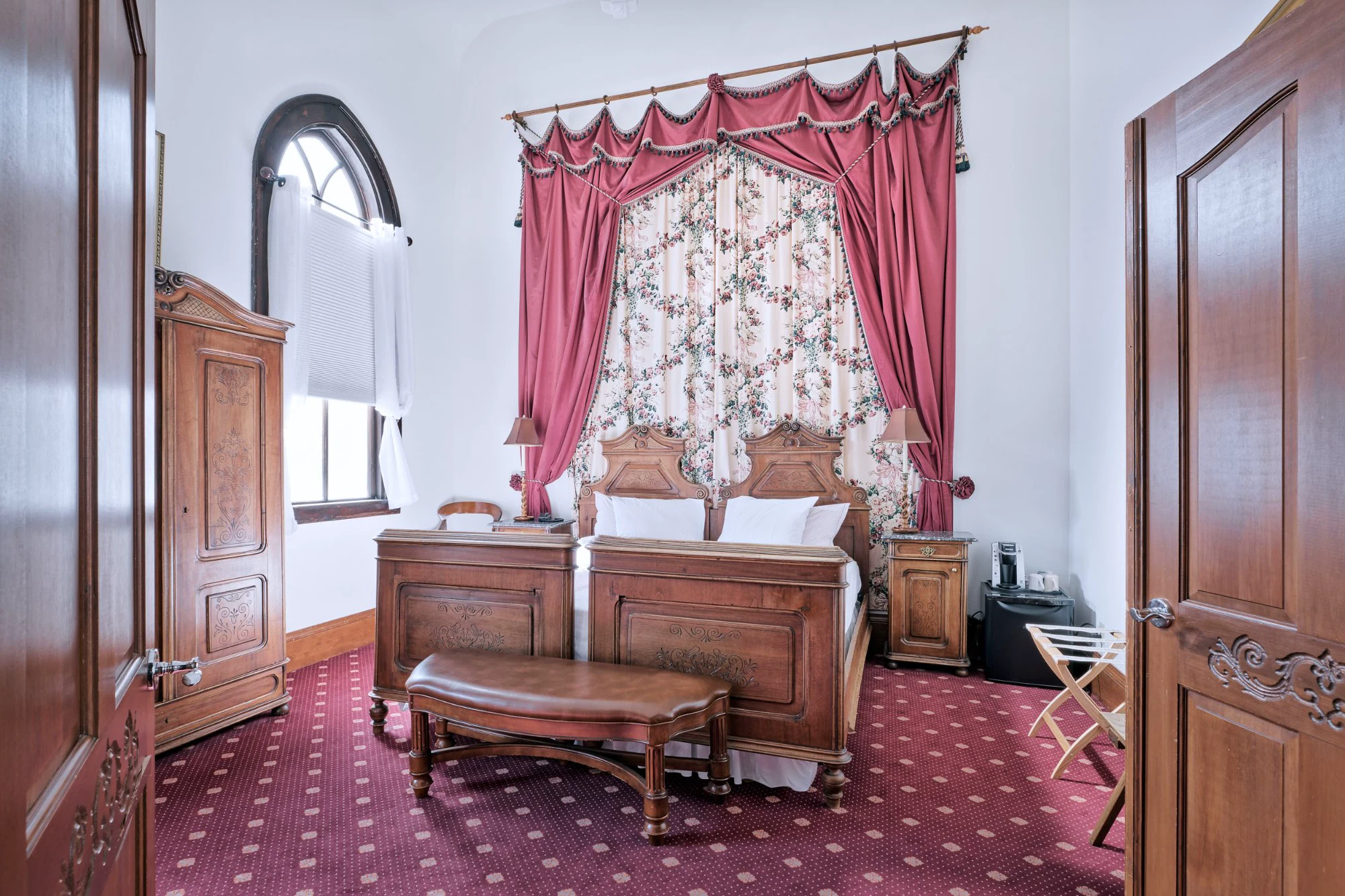 Alte Kapelle Suite bedroom with antique carved walnut bed and crimson canopy drapes
