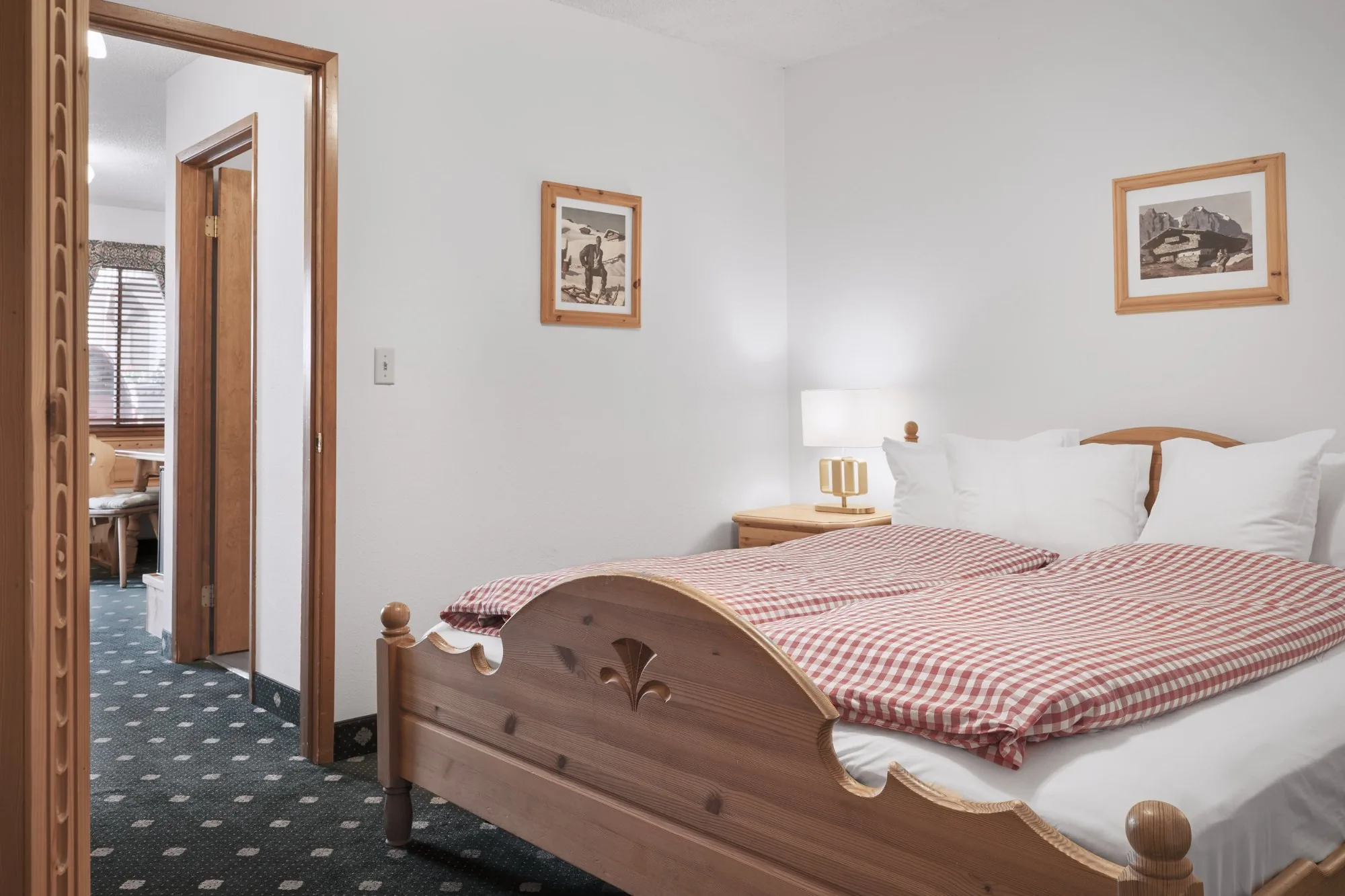 Alpbachtal — pine bed with carved footboard and doorway to sitting room